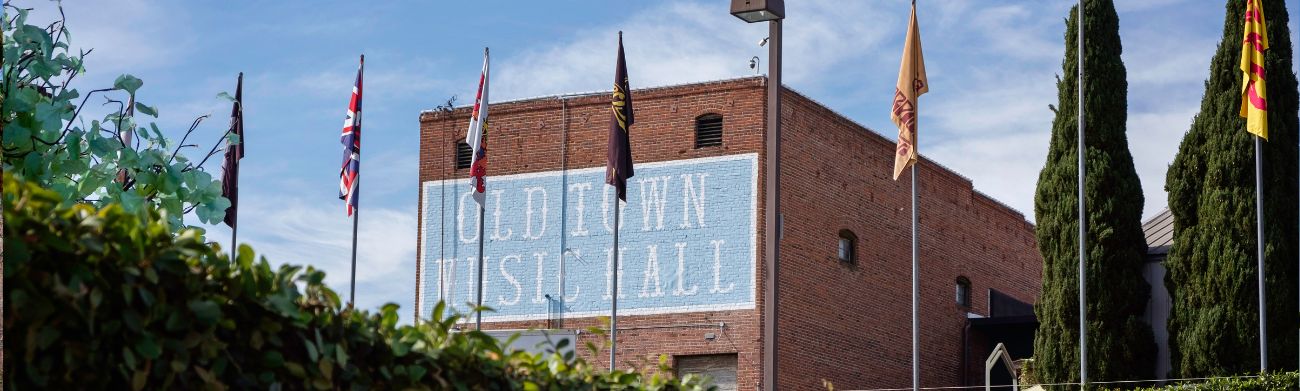 Exterior of Old Town Music Hall from back with flags